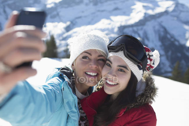 Amici che scattano selfie sulla neve — Foto stock