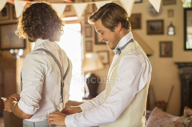 Bridegroom and best man preparing for wedding ceremony in domestic room — Stock Photo