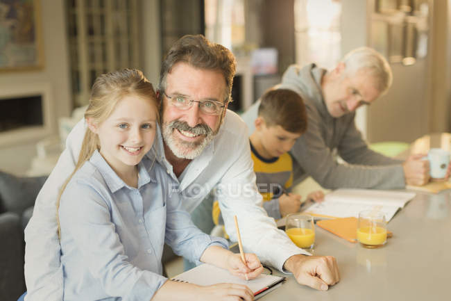 Portrait male gay parents helping children with homework at kitchen counter — Stock Photo