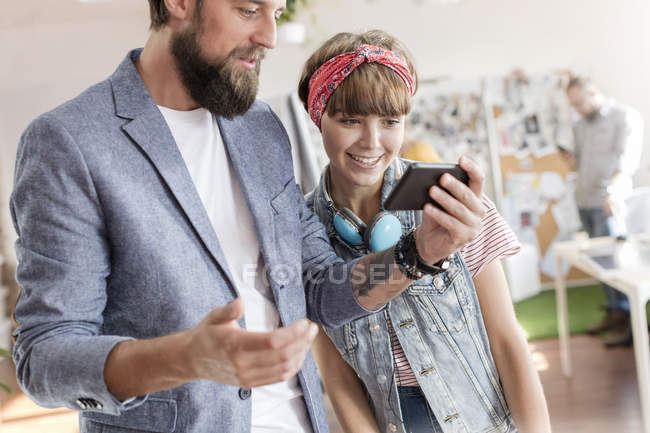 Design professionals using cell phone in office — Stock Photo