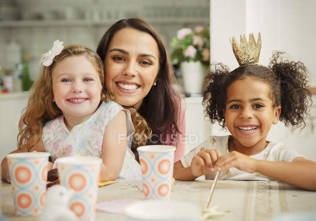 Retrato mãe sorridente e filhas na mesa de festa de aniversário — Fotografia de Stock