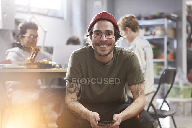 Портрет улыбающийся уверенный мужчина дизайнер с сотовым телефоном — стоковое фото