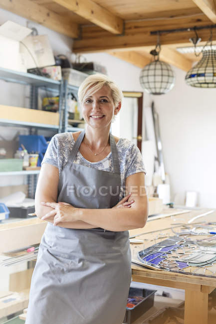 Portrait smiling stained glass artist in studio — Stock Photo