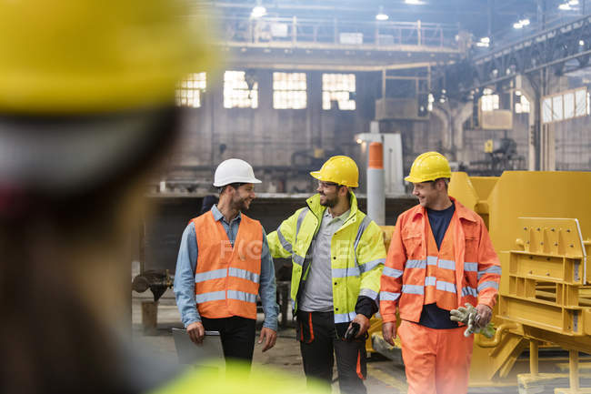 Stahlarbeiter gehen und reden in Fabrik — Stockfoto