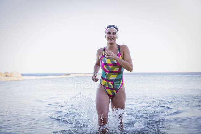 Feminino nadador ativo correndo no oceano ao ar livre — Fotografia de Stock