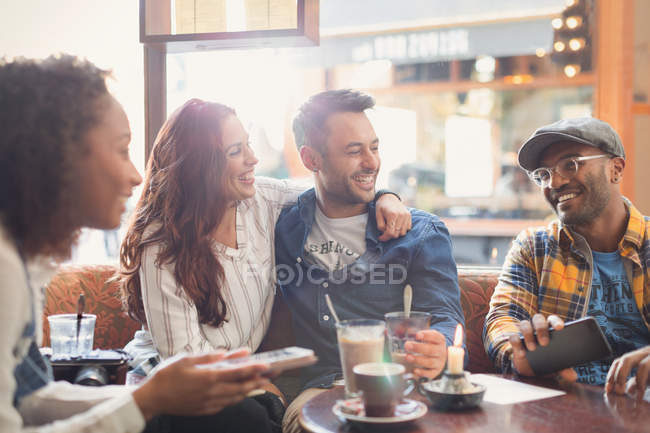 Lächelnde junge Pärchenfreunde hängen im Café herum — Stockfoto