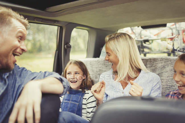Игривая семья смеется и поет в машине — стоковое фото