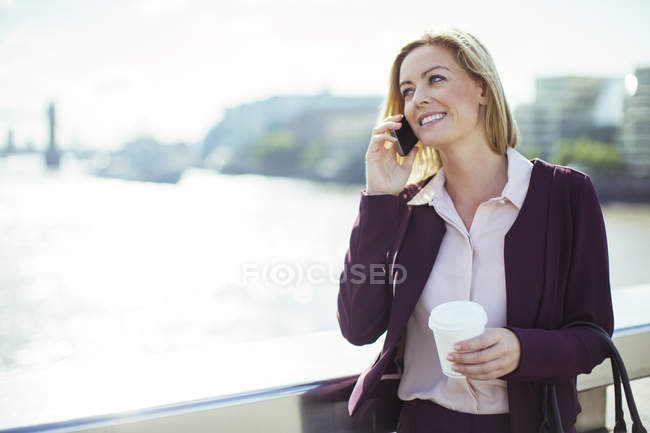 Бізнес-леді розмовляє по мобільному телефону на міському мосту — стокове фото