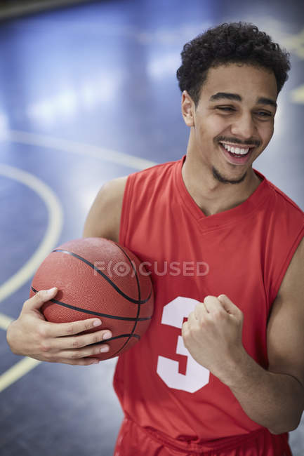 Retrato confiado, joven jugador de baloncesto feliz gesto victoria, celebrando en la cancha - foto de stock