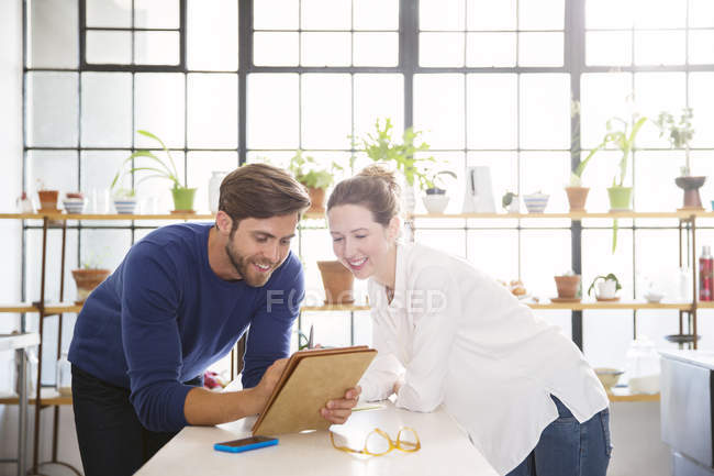 Двое молодых людей просматривают документы на кухне — стоковое фото