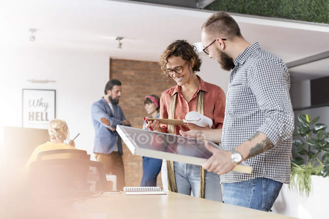 Smiling design professionals reviewing storyboard in office — Stock Photo