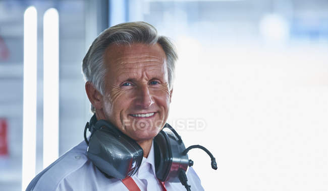 Retrato sonriente fórmula un gerente de carreras con auriculares - foto de stock