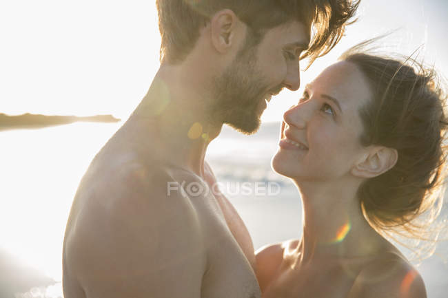 Jeune couple se regardant sur la plage — Photo de stock