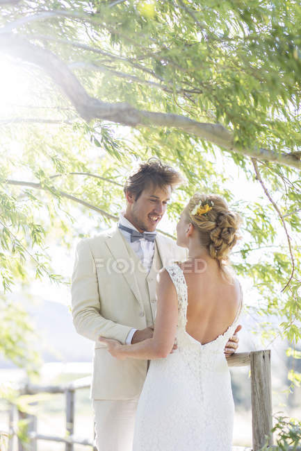 Giovane coppia che si abbraccia sul ponte di legno — Foto stock