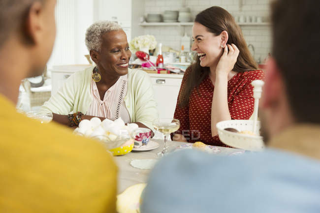 Mulheres sorridentes desfrutando de festa à mesa — Fotografia de Stock