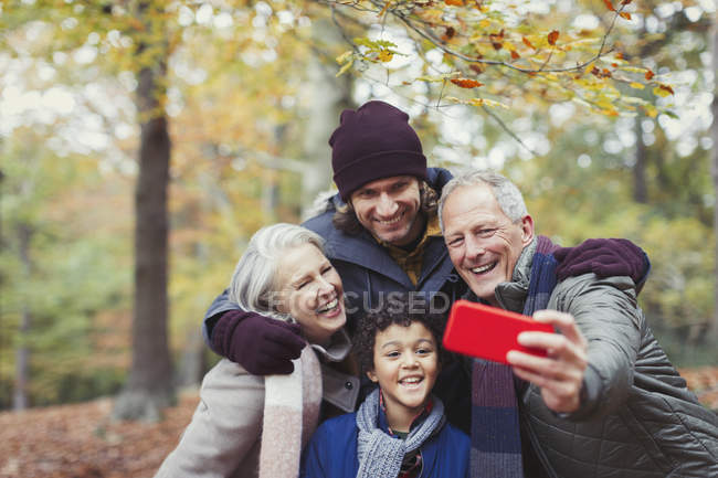 Família de várias gerações que toma selfie com telefone de câmera em florestas de outono — Fotografia de Stock