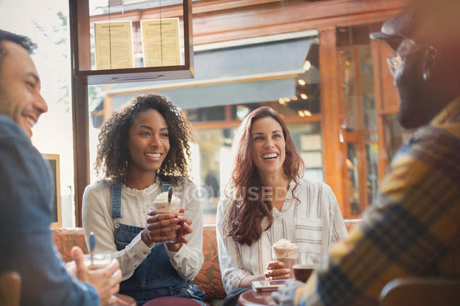 Freunde hängen mit heißer Schokolade im Café herum — Stockfoto