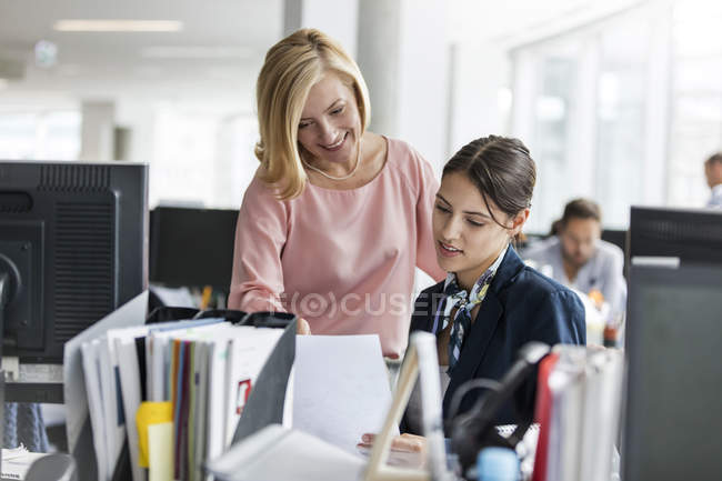 Empresarias discutiendo papeleo en oficina - foto de stock