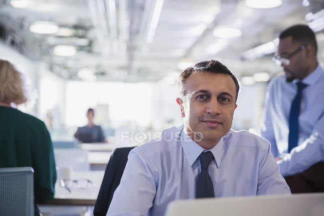 Ritratto uomo d'affari sicuro al computer portatile in ufficio — Foto stock