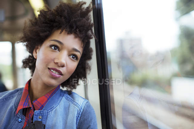 Femme rêveuse regardant par la fenêtre du train — Photo de stock