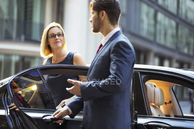 Chauffeur ouvrant porte de voiture pour femme d'affaires — Photo de stock
