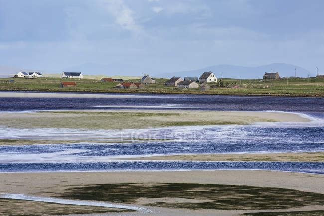 Vue ensoleillée village de pêcheurs et de l'eau, Oronsay, Uist Nord, Hébrides extérieures — Photo de stock
