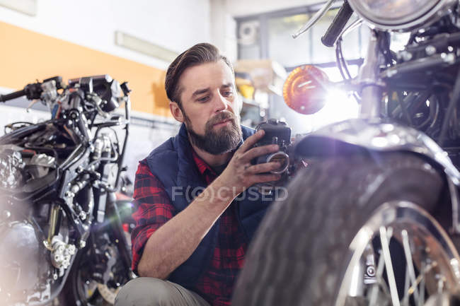 Mecânico de motocicleta fazendo teste de diagnóstico na motocicleta na oficina — Fotografia de Stock