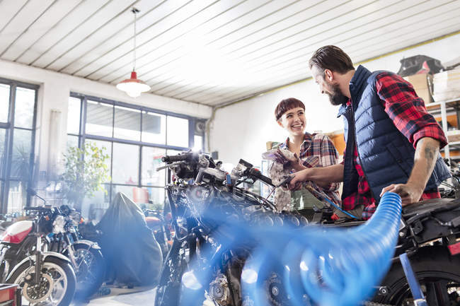 Meccanica motociclistica maschile e femminile riparazione moto in officina — Foto stock