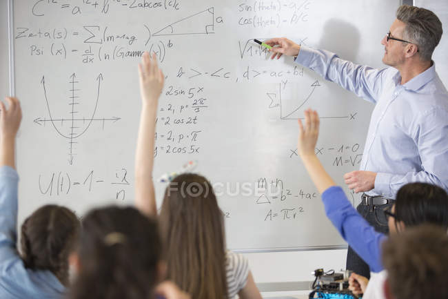 Insegnante di sesso maschile che conduce lezione di fisica alla lavagna in classe — Foto stock
