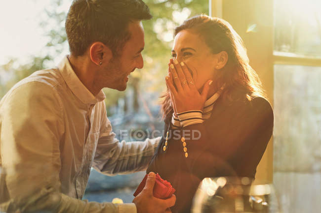 Novio proponiendo a sorprendido, feliz novia en la cafetería - foto de stock