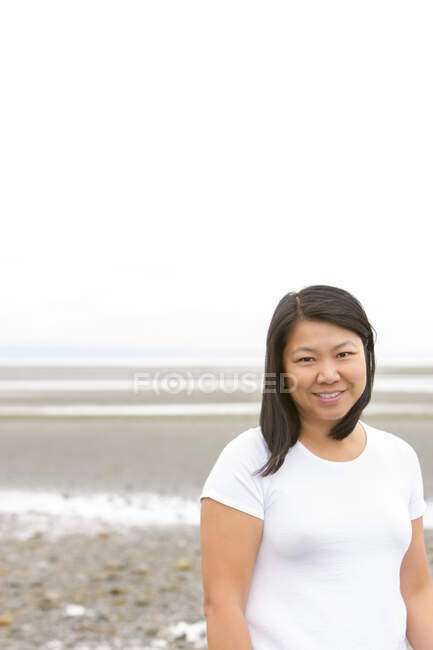 Портрет, який посміхається китайці на переповненому пляжі — стокове фото