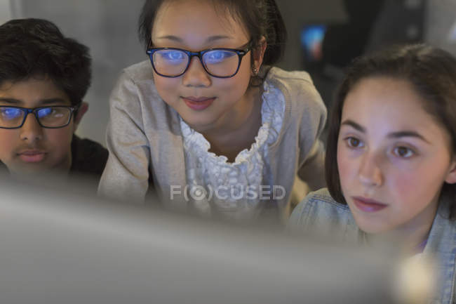 Focused students using computer in dark classroom — Stock Photo