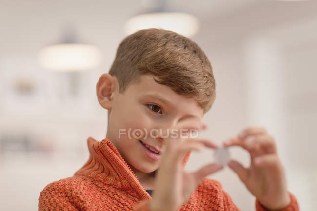 Любопытный мальчик с монетой, крупным планом — стоковое фото