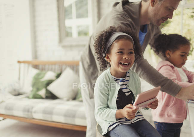 Lachendes Mädchen mit digitalem Tablet im Wohnzimmer — Stockfoto