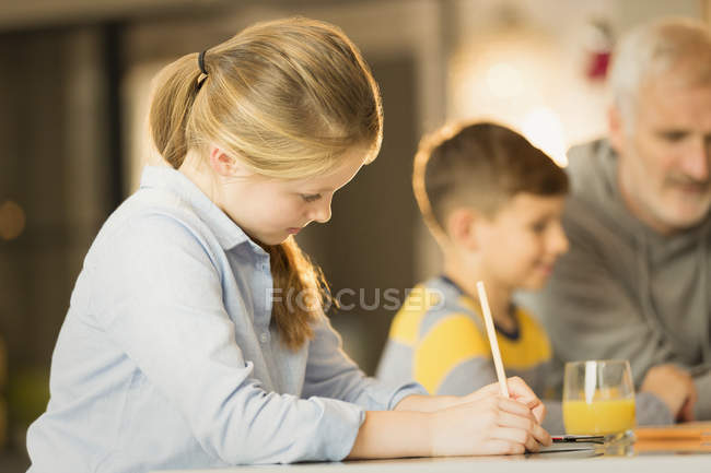 Menina fazendo lição de casa no balcão, fundo borrado — Fotografia de Stock
