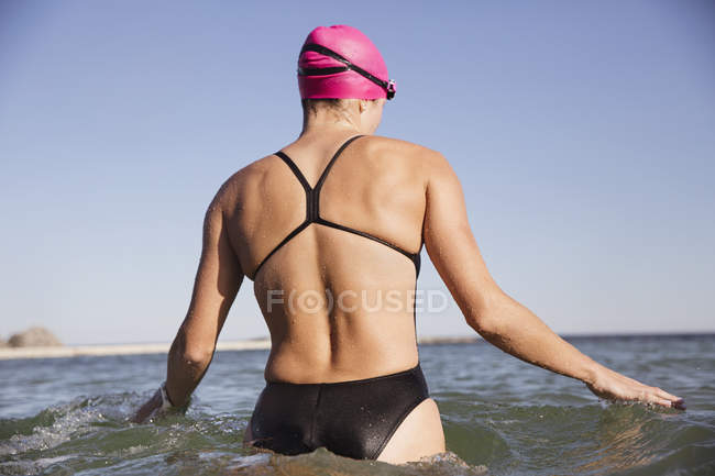 Feminino nadador ativo em pé na água do oceano ao ar livre — Fotografia de Stock