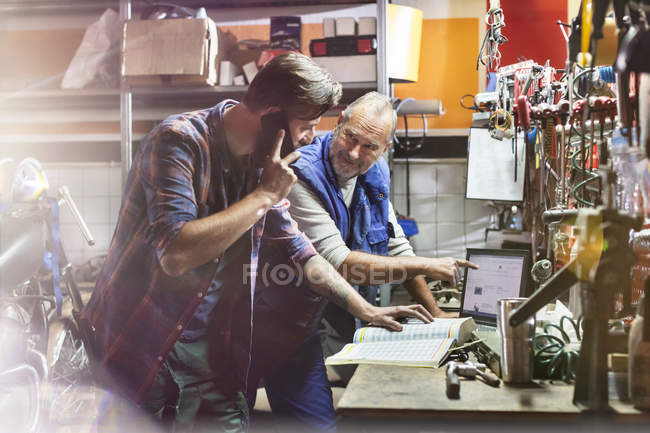 Motorcycle mechanics working in workshop — Stock Photo