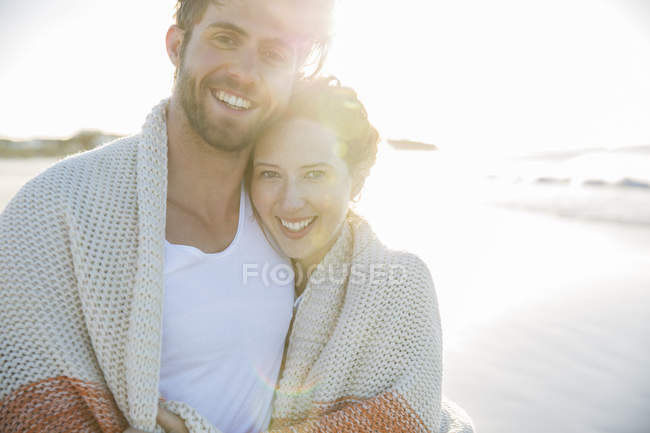 Retrato de pareja joven de pie en la playa - foto de stock