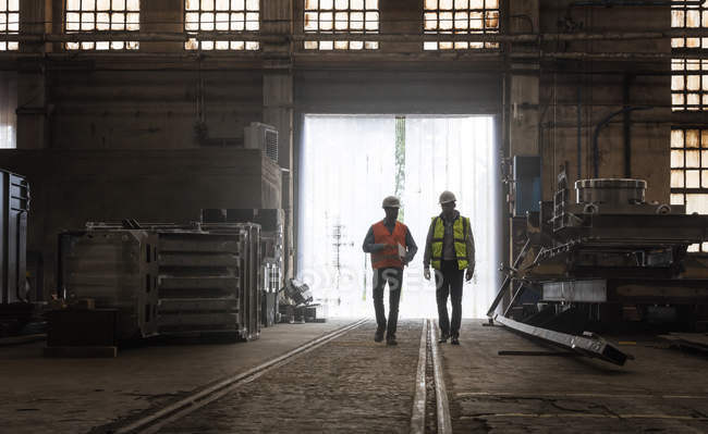Trabajadores del acero caminando en fábrica - foto de stock