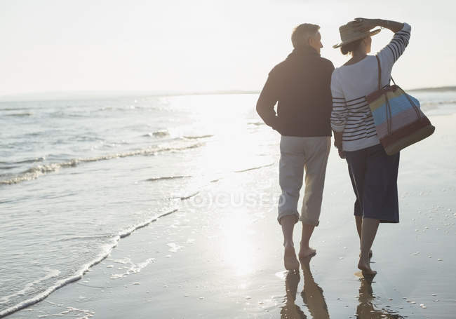 Casal maduro andando na praia do oceano ensolarado — Fotografia de Stock