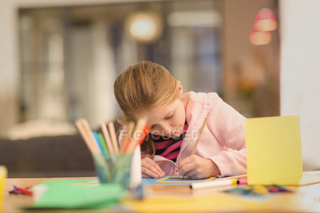 Focused girl drawing, doing crafts at table — Stock Photo