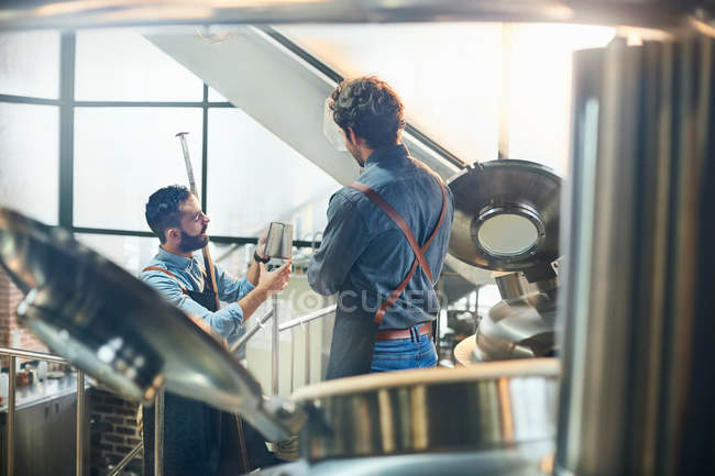 Coffee roasters talking at vats — Stock Photo