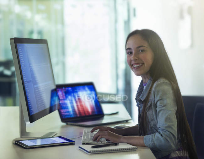 Retrato sonriente, chica confiada estudiante programación en la computadora en el aula - foto de stock