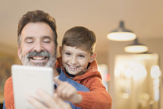 Батько і син зв'язуються, ділячись цифровим планшетом — стокове фото