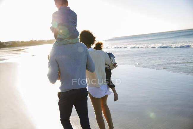 Heureuse famille marchant sur la plage — Photo de stock