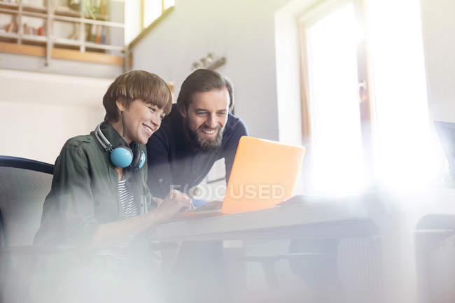 Riunione dei professionisti del design sorridenti al laptop in ufficio — Foto stock