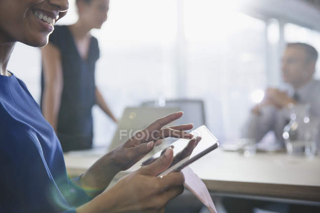 Close up smiling businesswoman using digital tablet in conference room meeting — Stock Photo