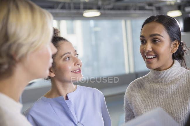 Деловые женщины говорят в современном офисе вместе — стоковое фото
