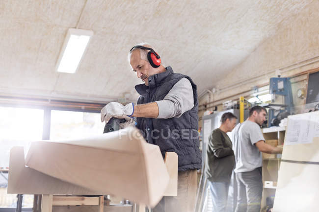 Senior Schreiner mit Schleifmaschine, Holzboot in Werkstatt schleifen — Stockfoto
