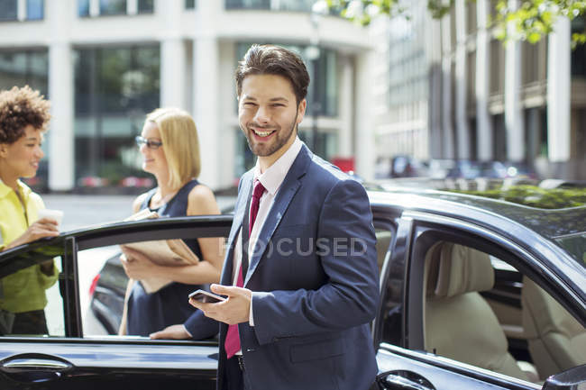 Businessman smiling outside car — Stock Photo